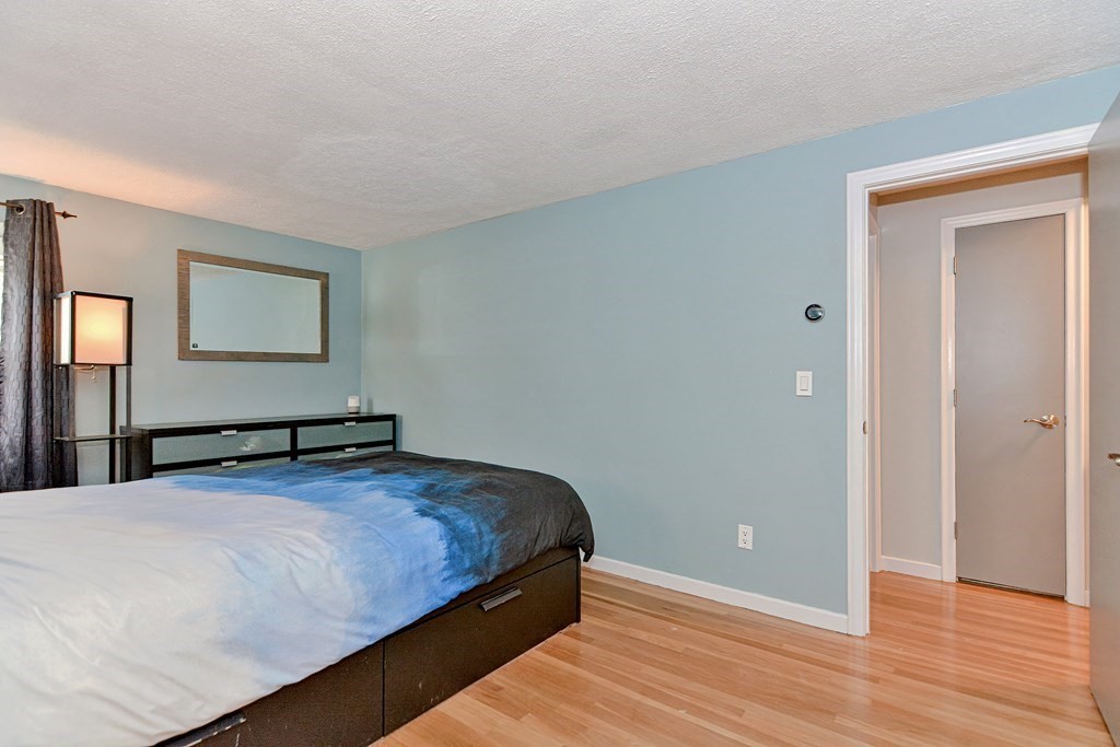 9 Doane Road Medford, MA 02155 - Photo 19 of 28 a bedroom with a bed and wooden floor