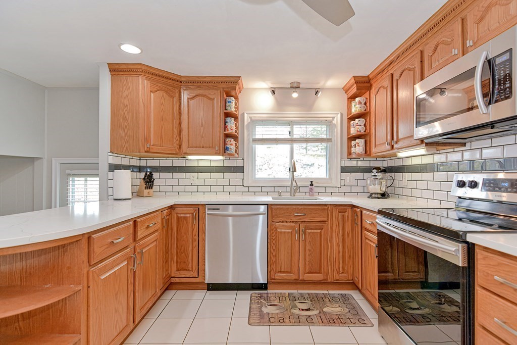 9 Doane Road Medford, MA 02155 - Photo 8 of 28 a kitchen with stainless steel appliances granite countertop a sink stove and cabinets