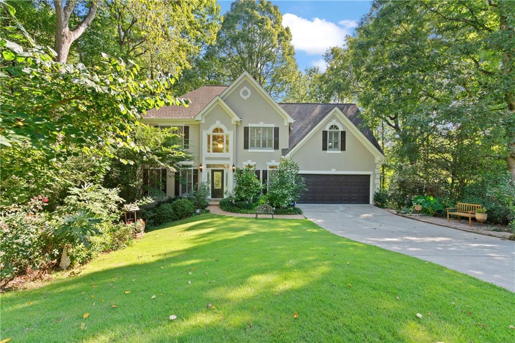 a front view of a house with a yard and trees