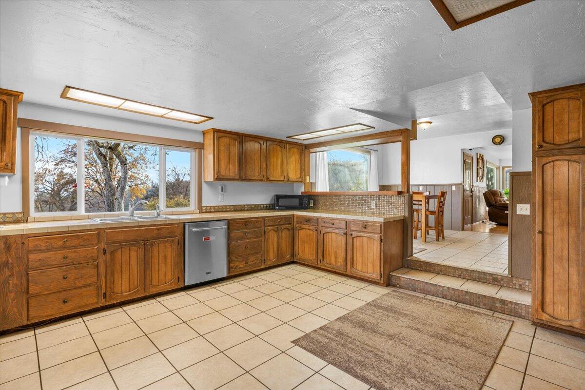 1360 Oxyoke Road Grants Pass, OR 97526 - Photo 10 of 39 a large kitchen with stainless steel appliances kitchen island granite countertop a large counter top and a stove
