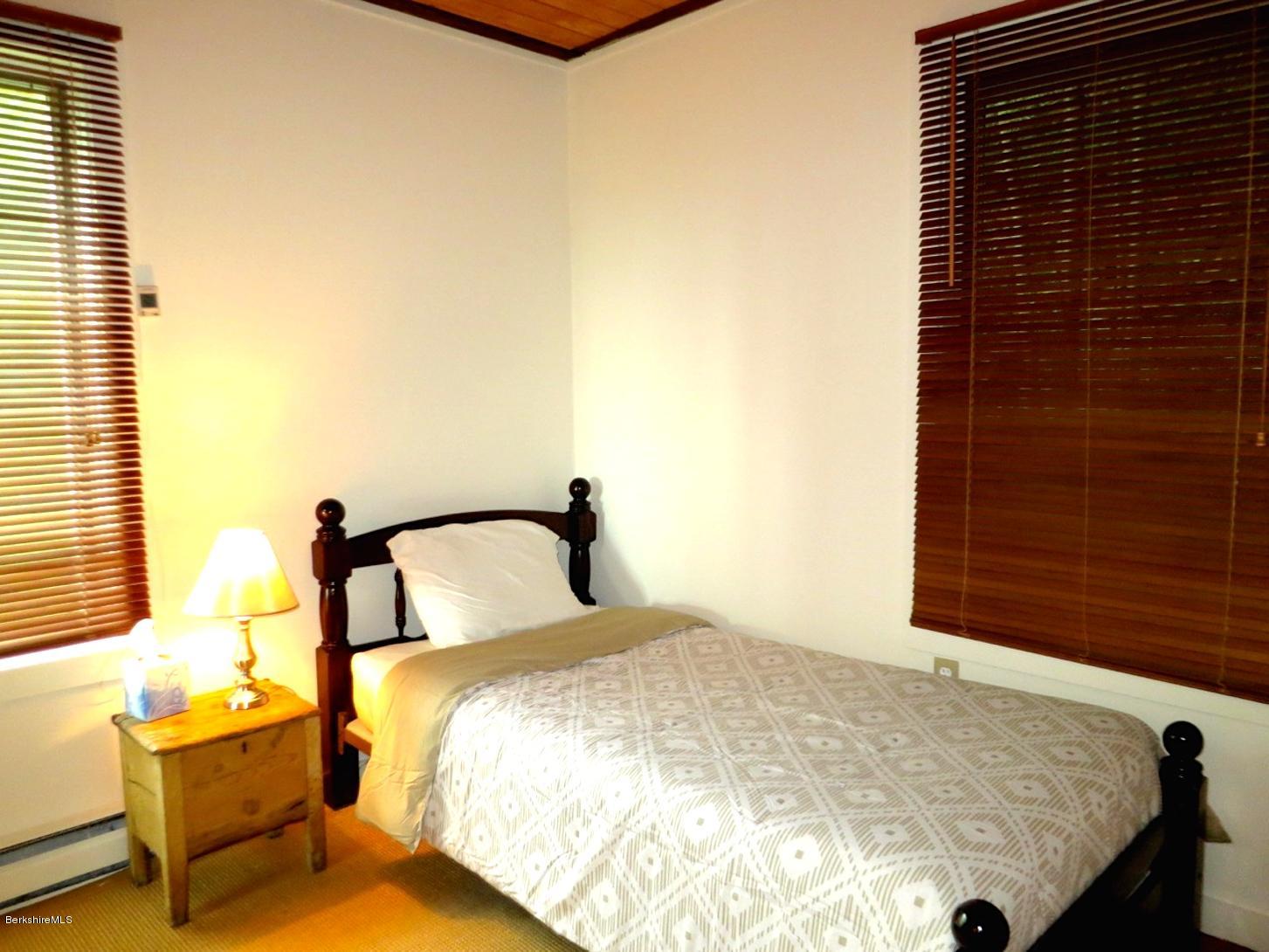 116 Hupi Road Monterey, MA 01245 - Photo 10 of 17 a bedroom with a bed and lamp next to a window