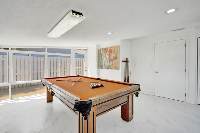 a room with pool table and windows