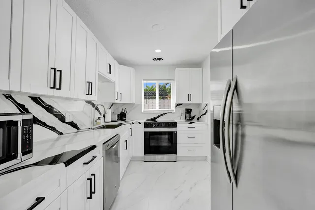 a kitchen with stainless steel appliances a sink stove and refrigerator
