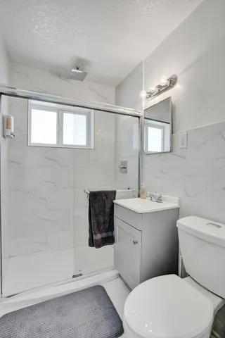 a bathroom with a sink a toilet and shower