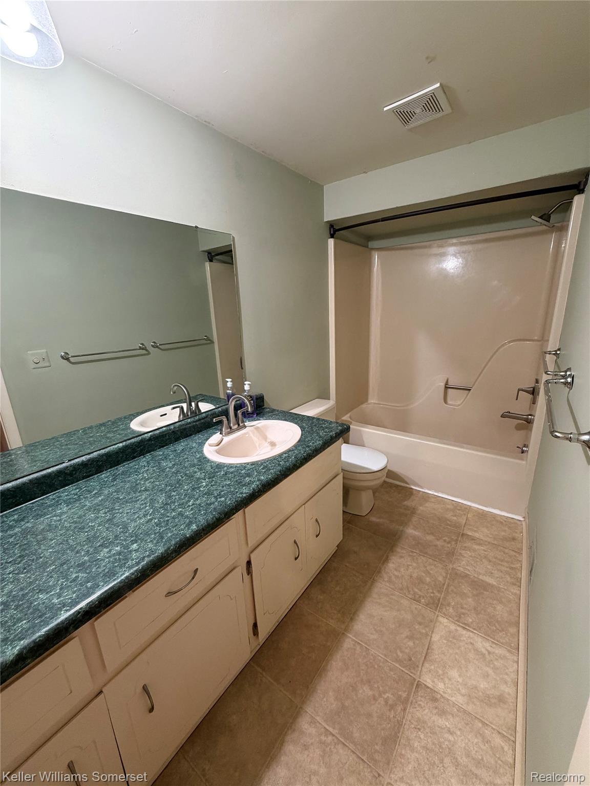 3277 Eastern Avenue Rochester, MI 48307 - Photo 9 of 13 Bathroom featuring a full-width vanity with dual sinks, a speckled green countertop, and white cabinetry