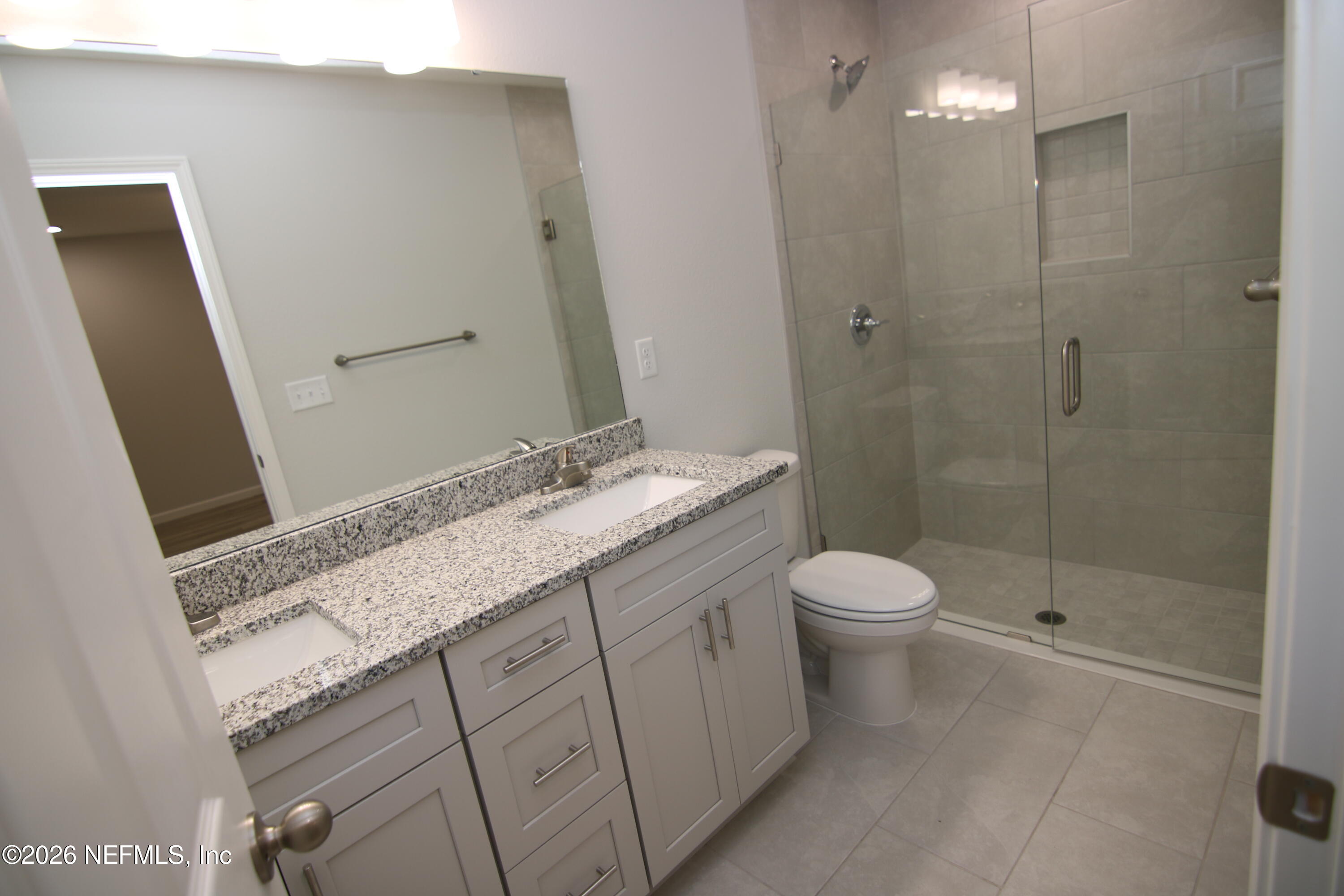 853 Jackson Road Jacksonville, FL 32225 - Photo 11 of 18 a bathroom with a granite countertop sink a toilet and shower