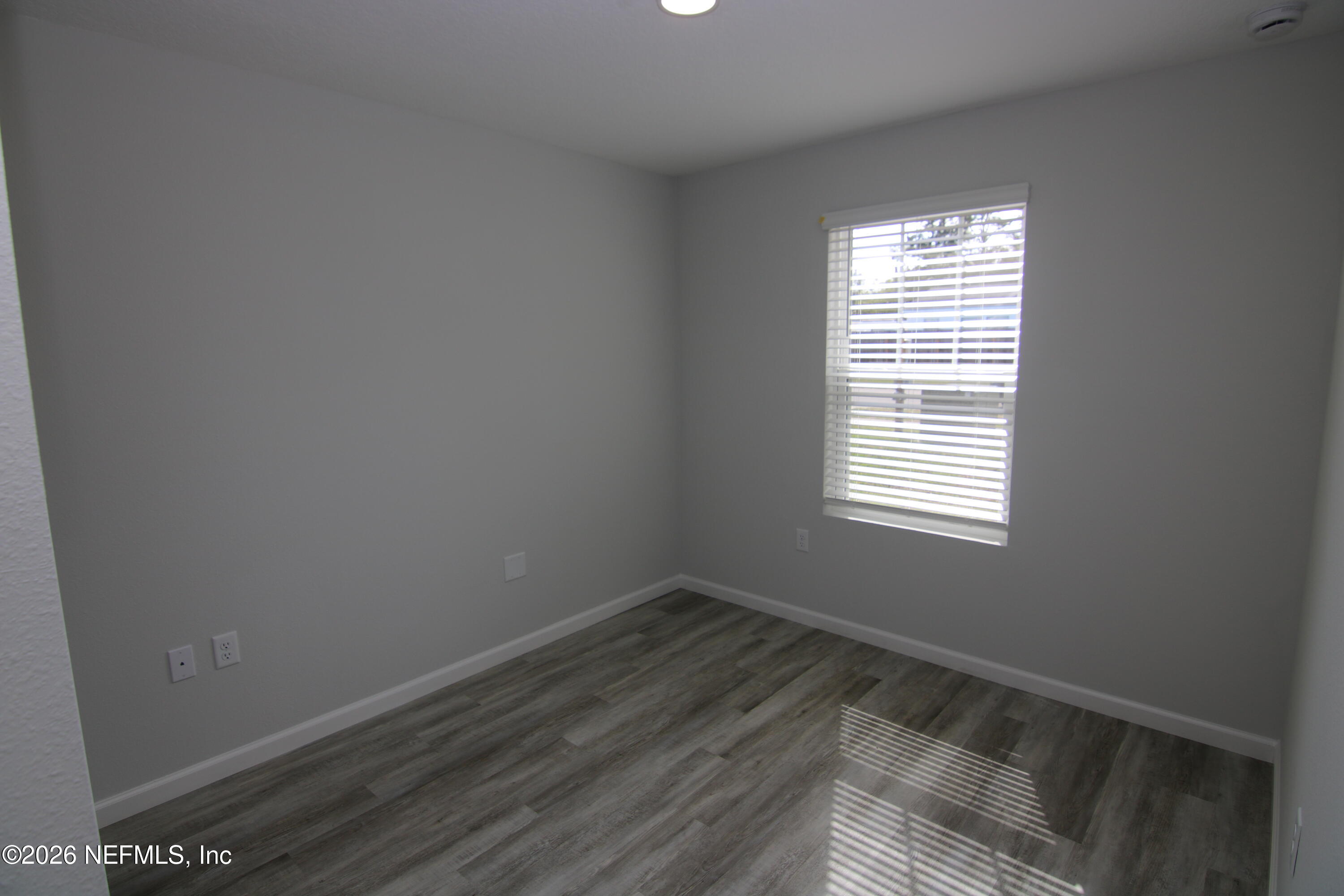 853 Jackson Road Jacksonville, FL 32225 - Photo 16 of 18 a view of an empty room with wooden floor and a window