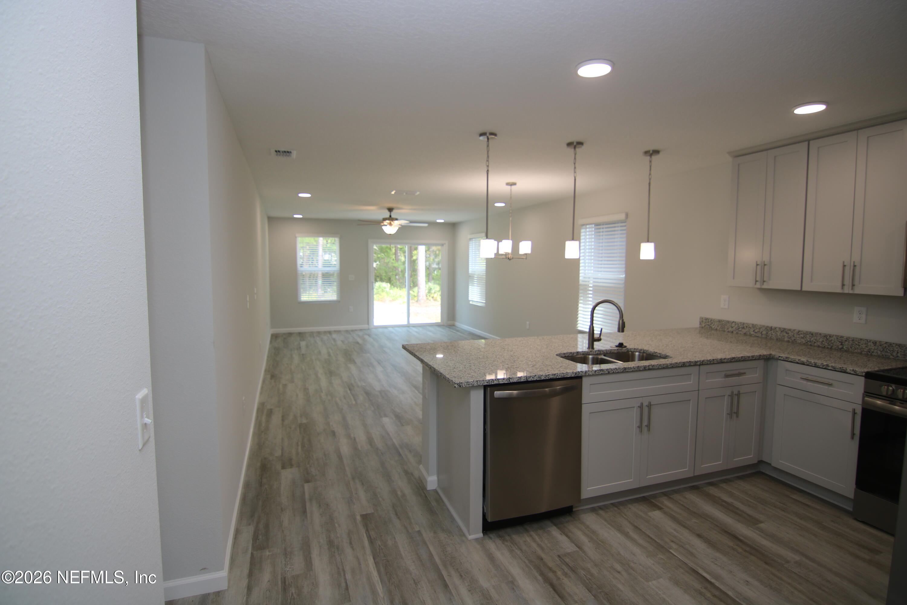853 Jackson Road Jacksonville, FL 32225 - Photo 17 of 18 a kitchen with stainless steel appliances granite countertop a sink a stove and a wooden floors