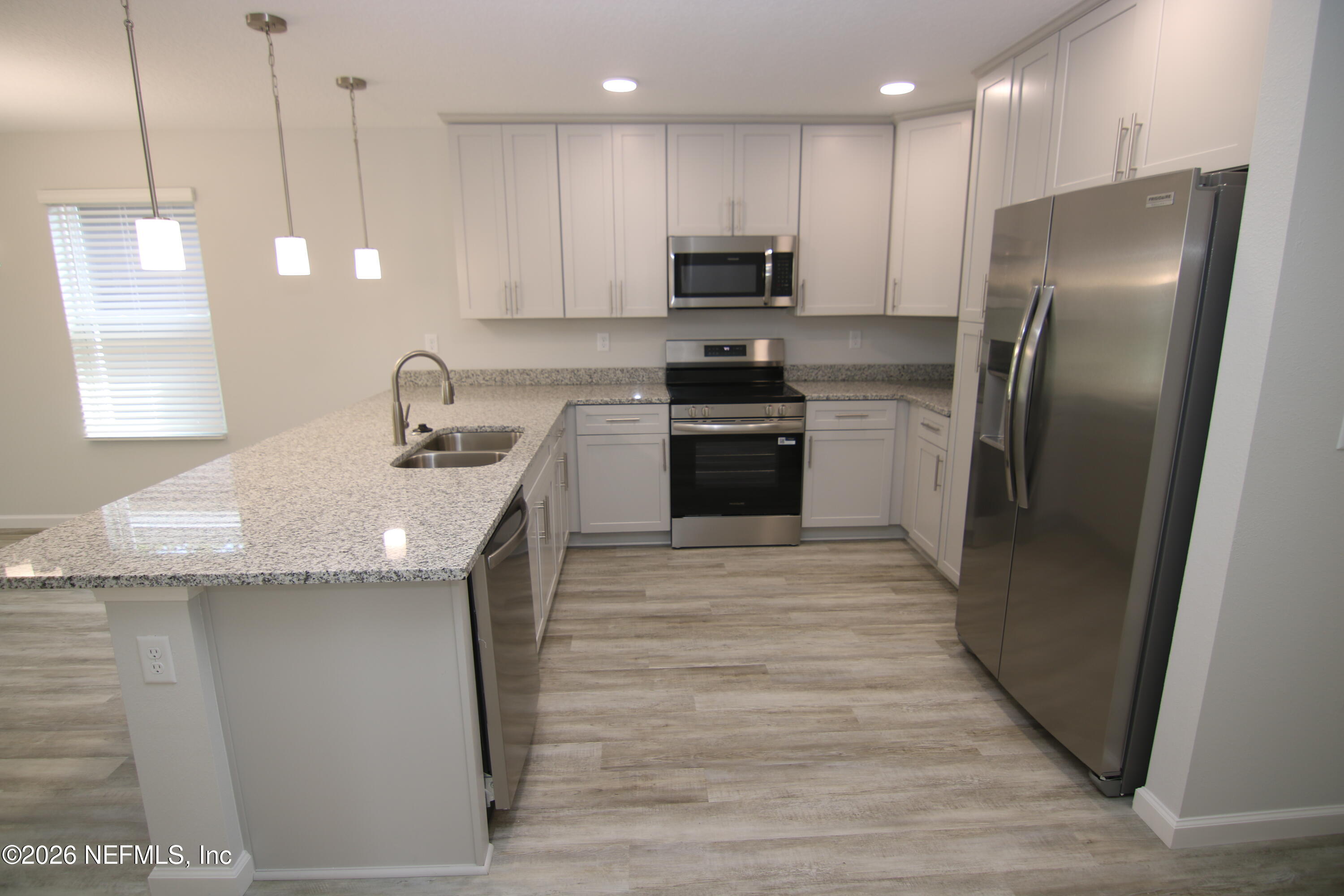 853 Jackson Road Jacksonville, FL 32225 - Photo 5 of 18 a kitchen with kitchen island granite countertop a sink a counter space appliances and cabinets
