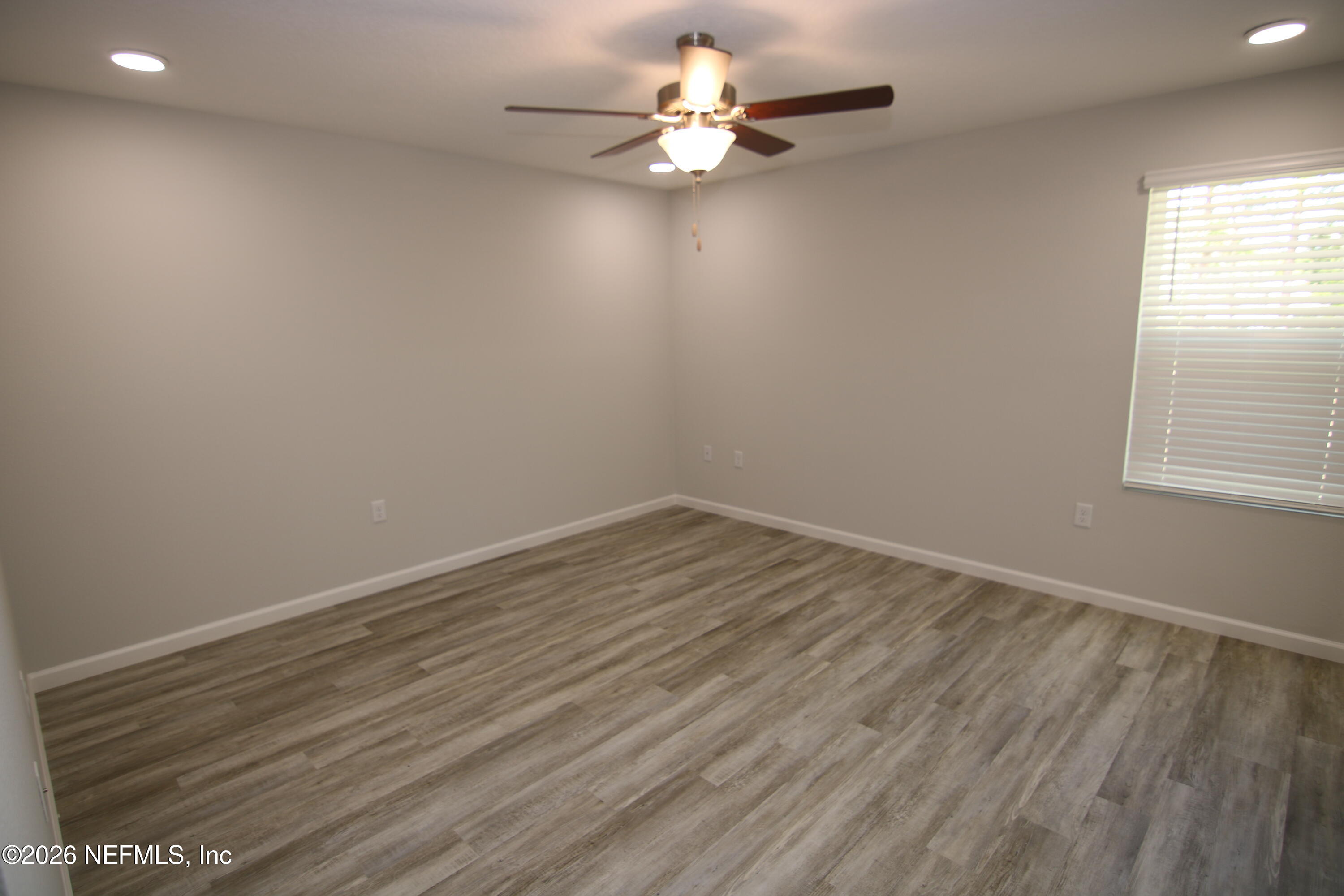 853 Jackson Road Jacksonville, FL 32225 - Photo 10 of 18 wooden floor in an empty room with a window