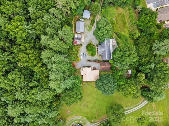 an aerial view of residential house with outdoor space and trees all around