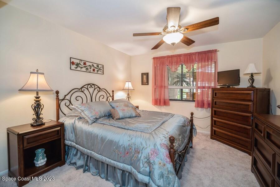 1638 Dawes Road Northeast Palm Bay, FL 32905 - Photo 11 of 26 a bedroom with a bed and a chandelier