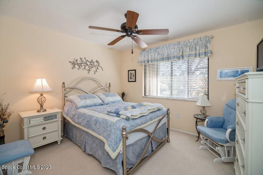 1638 Dawes Road Northeast Palm Bay, FL 32905 - Photo 13 of 26 a bedroom with a bed and a chandelier