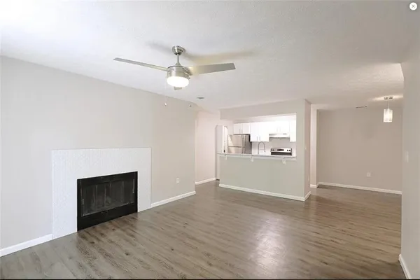 a view of empty room with wooden floor and fireplace