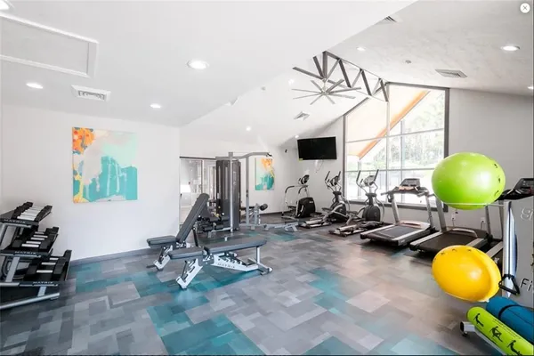 a room with gym equipment and a chandelier