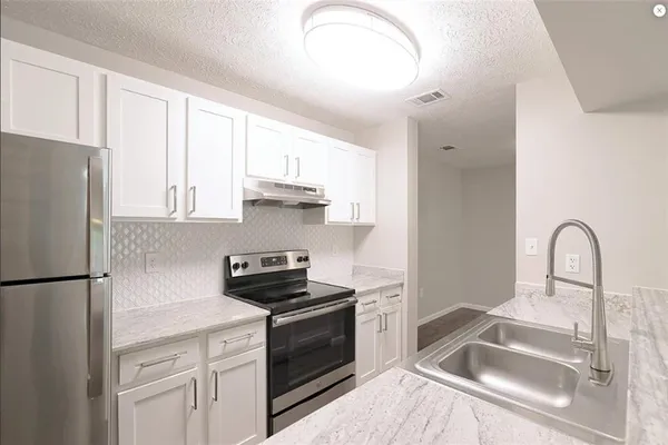 a kitchen with a refrigerator sink and cabinets