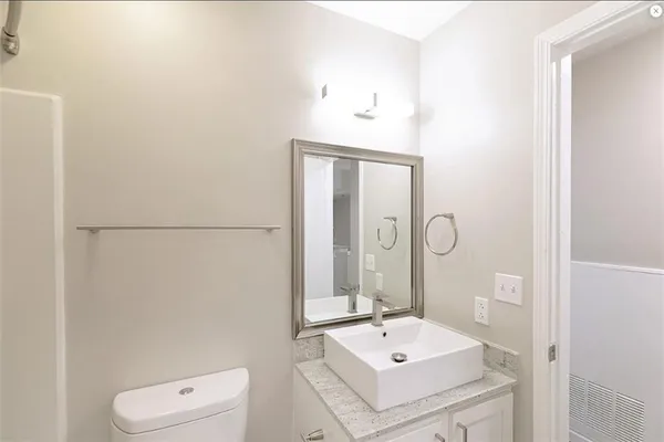 a bathroom with a sink a toilet and mirror