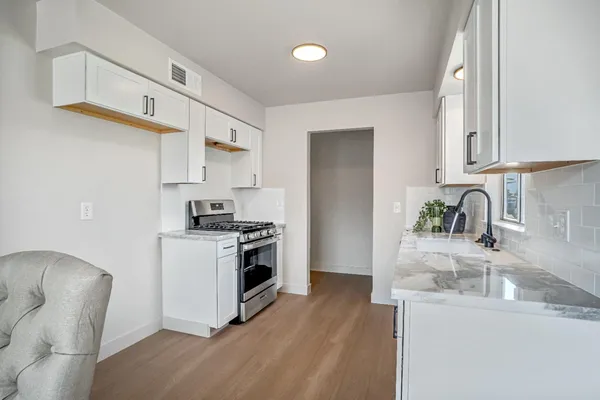a kitchen with stainless steel appliances granite countertop a sink stove and refrigerator