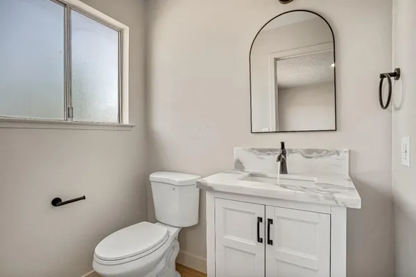 a bathroom with a sink a toilet and mirror