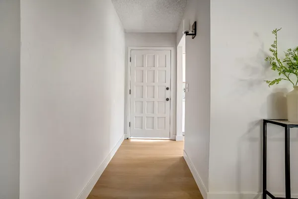 a view of a hallway with wooden floor