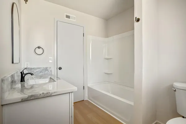 a bathroom with a granite countertop sink toilet and shower