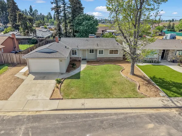 a aerial view of a house with a yard and potted plants