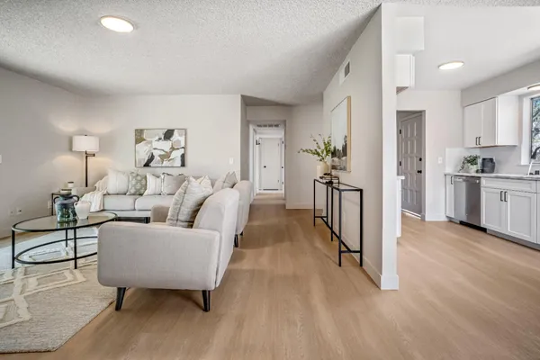 a living room with furniture and a wooden floor