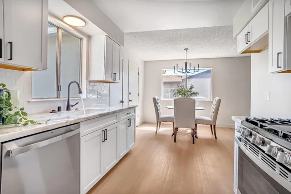 a kitchen with a table chairs stove and cabinets