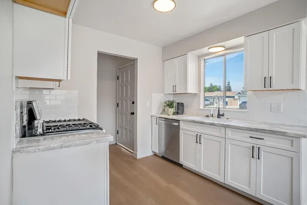 a kitchen with white cabinets and a stove
