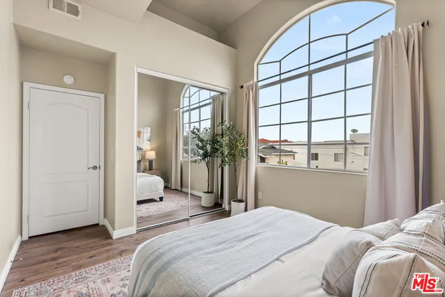 a bedroom with a bed and a large window
