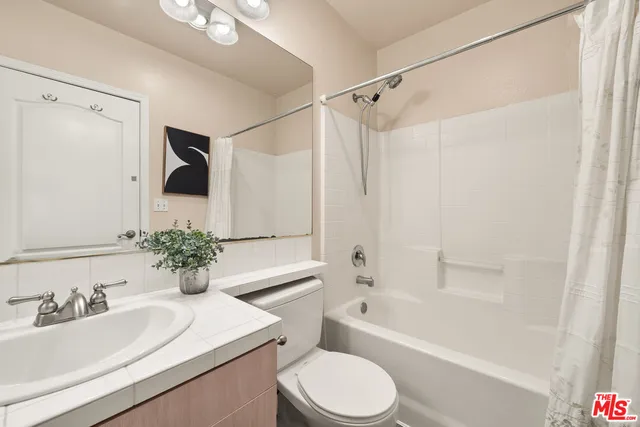 a bathroom with a sink toilet a mirror and shower