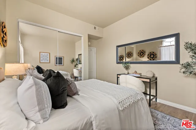 a bedroom with a bed and a painting on the wall