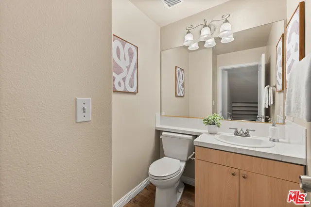 a bathroom with a toilet sink vanity and mirror