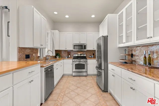 a kitchen with granite countertop a stove sink and refrigerator