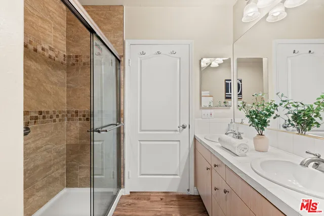 a bathroom with a double vanity sink and shower