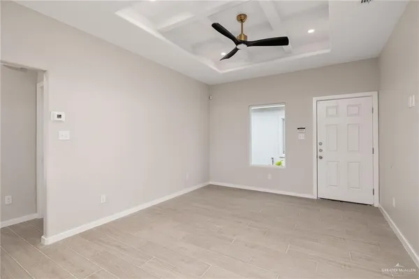 an empty room with a ceiling fan and window