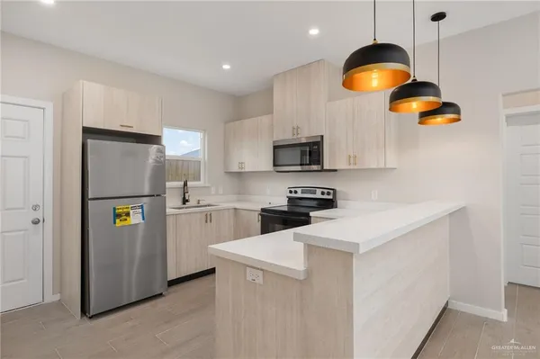 a kitchen with stainless steel appliances a refrigerator a stove a microwave oven a sink and dishwasher