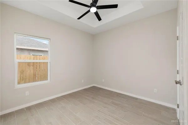 an empty room with a window and a ceiling fan