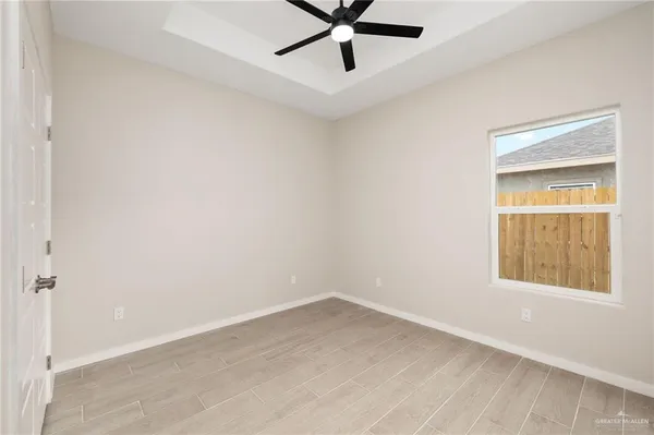 an empty room with a window and a fan