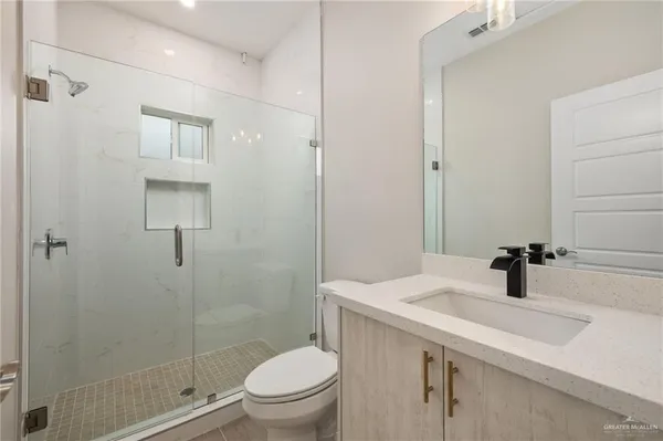 a bathroom with a sink a toilet and shower