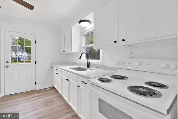 a kitchen with a stove a sink and a window
