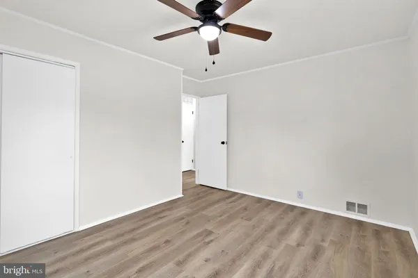 an empty room with wooden floor ceiling fan and a ceiling fan