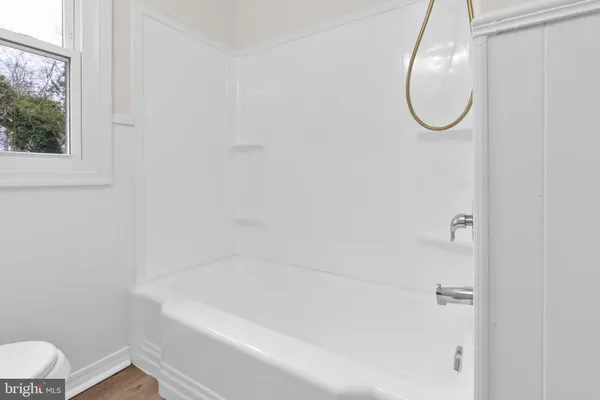 a bathroom with a white bath tub and a shower
