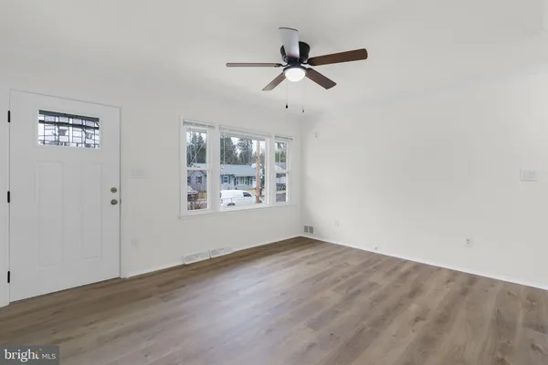 a view of room with hardwood floor and a ceiling fan