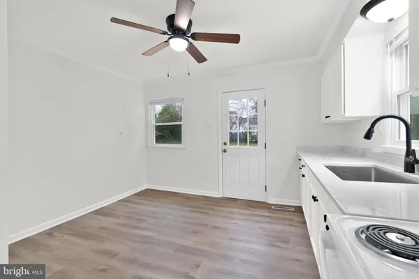a view of a kitchen with a sink hardwood floor and a ceiling fan