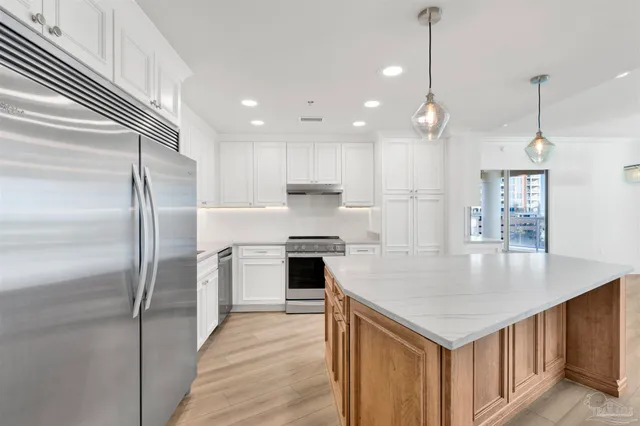 a kitchen with granite countertop white cabinets and white stove