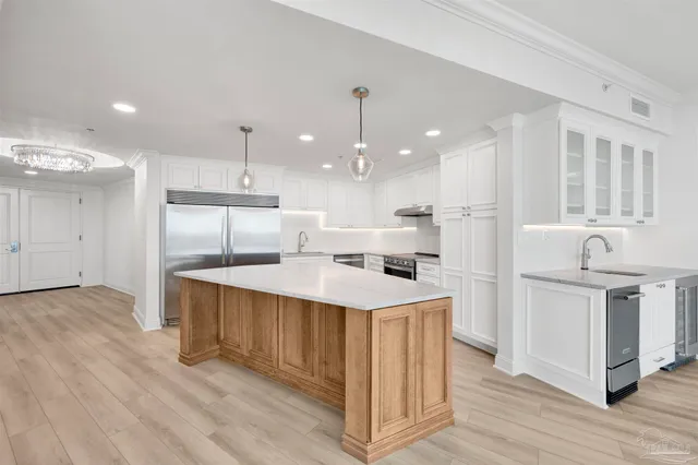 a kitchen with stainless steel appliances granite countertop a lot of counter space and wooden floors