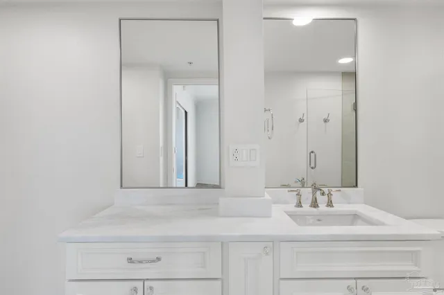 a bathroom with a granite countertop sink a toilet and shower