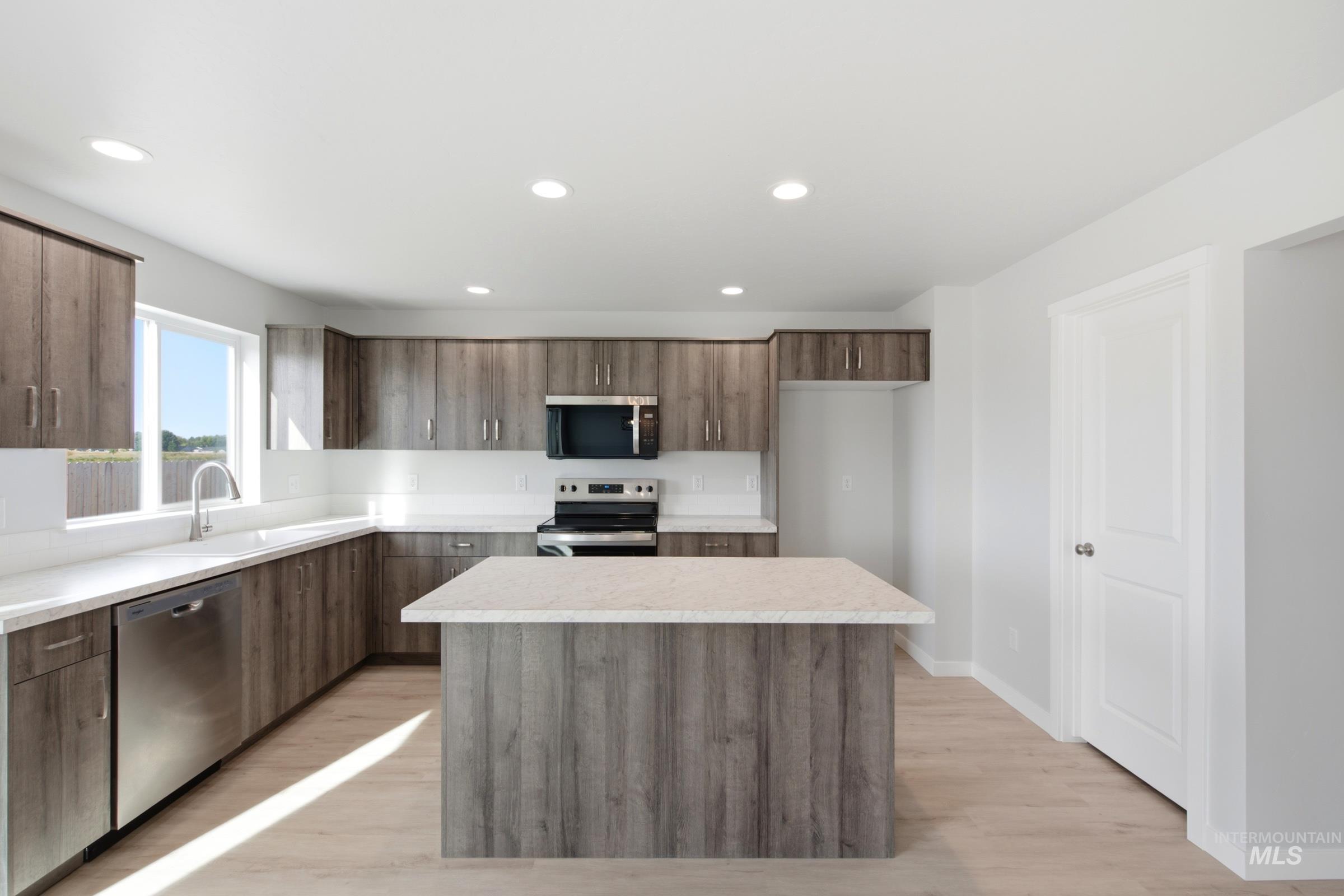 13324 Bank Street Caldwell, ID 83607 - Photo 3 of 29 Kitchen featuring wood-finish cabinetry, stainless steel appliances, a center island with countertop, an undermount sink, and recessed lighting