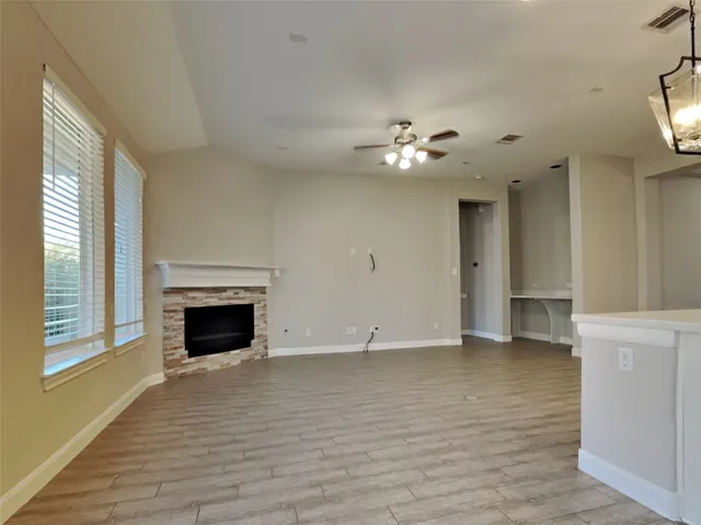 a view of an empty room with a fireplace and a window